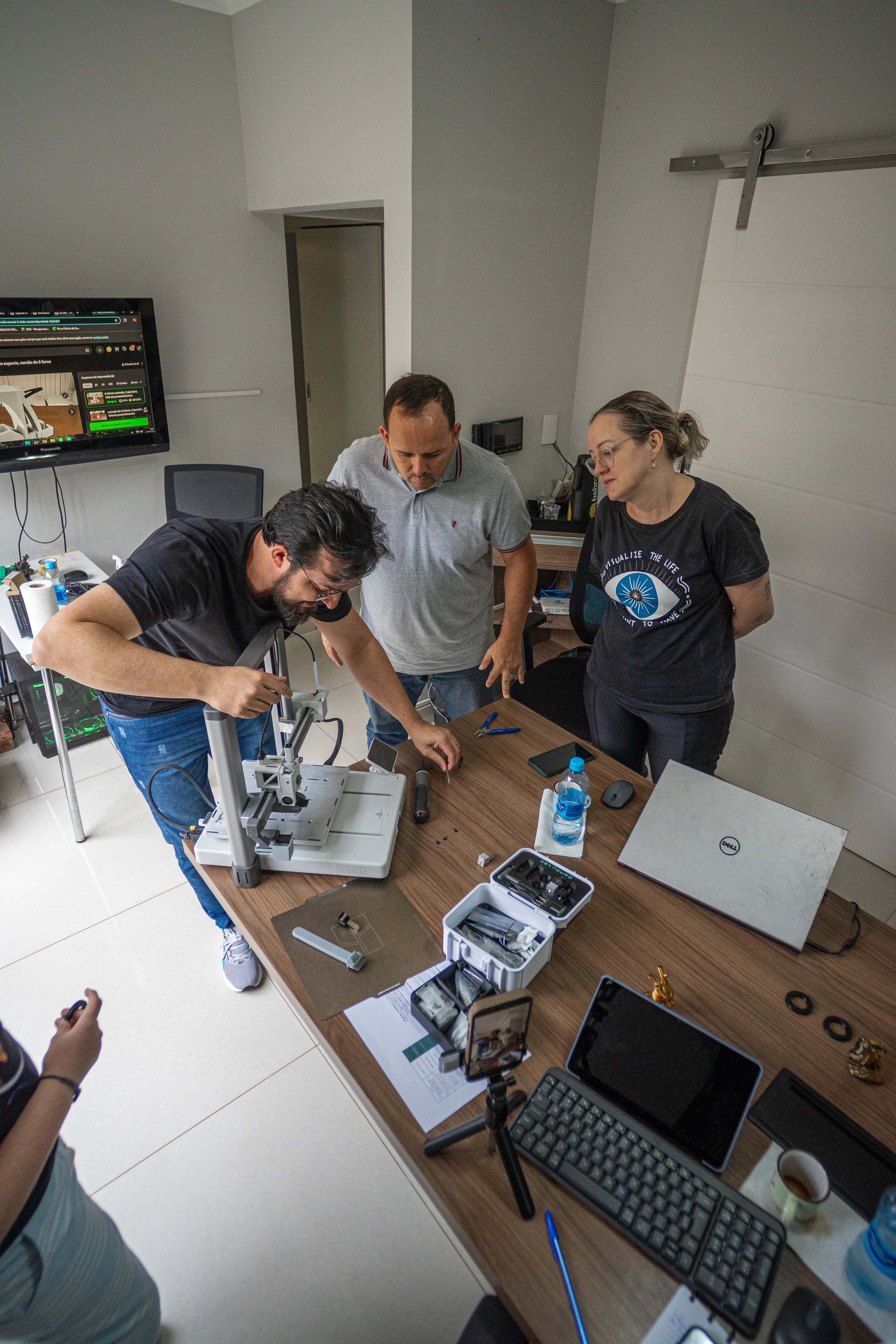 Everton faz uma demonstração prática em uma impressora 3D enquanto participantes observam